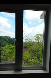 a window with a view of a forest at Happy Stays B - End Unit Greenery View at SMDC Hope Residences in Trece Martires
