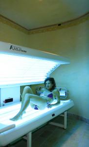een vrouw in bikini zittend op een bed bij Hotel Crepes de Sela in Campitello di Fassa