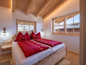 a bedroom with a large bed with red pillows at Ferienhaus Weberhof in Hopfgarten im Brixental