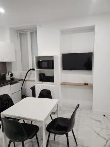 - une cuisine blanche avec une table et des chaises blanches dans l'établissement Appartement dans le 8e arrondissement de Lyon (T2), à Lyon