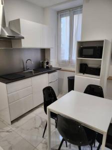 une cuisine avec un évier et une table avec des chaises dans l'établissement Appartement dans le 8e arrondissement de Lyon (T2), à Lyon