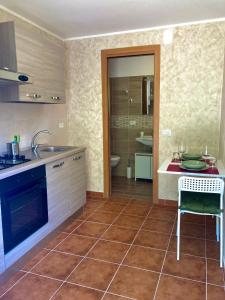 uma cozinha com um balcão, um lavatório e uma mesa em Serendipity Apartment em Castelmola