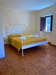 um quarto com uma cama com uma colcha amarela em Serendipity Apartment em Castelmola