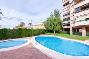 a swimming pool in front of a building at 2 Bed apartment near the beach with pool in El Campello