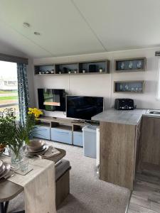 a kitchen with a counter and a table and a tv at Ingoldmells Honeybee Fantasy Island in Lincolnshire