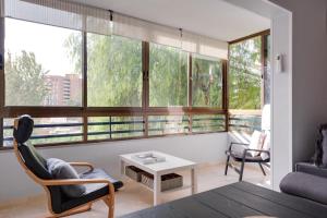 a living room with a table and chairs and windows at 2 Bed apartment near the beach with pool in El Campello