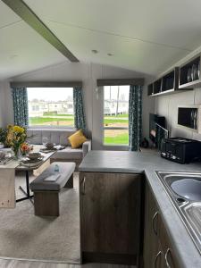 a kitchen and living room with a couch and a table at Ingoldmells Honeybee Fantasy Island in Lincolnshire
