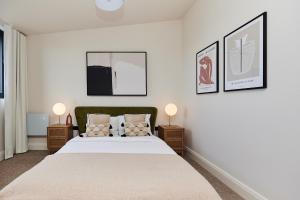 倫敦的住宿－The South Woodford Place - Adorable 2BDR Flat with Balcony，一间卧室配有一张大床和两盏灯。
