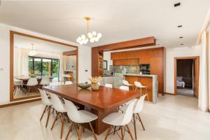a dining room and kitchen with a wooden table and chairs at Villa Istria Green in Kršan