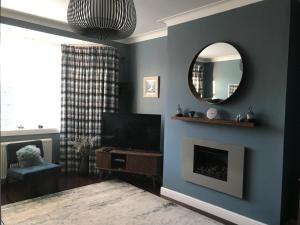 sala de estar con TV y espejo en Ultra Stylish furnished Home in Edinburgh en Edimburgo