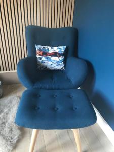 a blue chair with a pillow on top of it at Ultra Stylish furnished Home in Edinburgh in Edinburgh