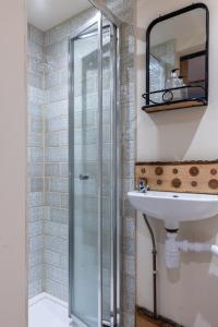 a bathroom with a glass shower and a sink at Adorable and Cosy Tiny Cottage in Heathfield