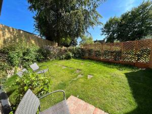 a yard with two chairs and a fence at Adorable and Cosy Tiny Cottage in Heathfield