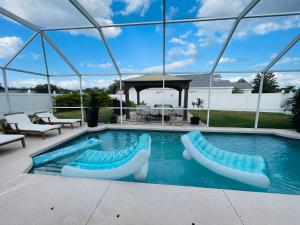 uma piscina com duas cadeiras e um gazebo em Paradise Home 3 Near IMG Academy & Siesta Key Beach em Bradenton