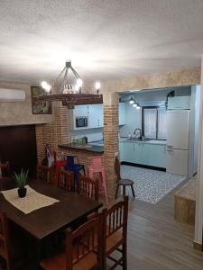 uma cozinha e sala de estar com mesa e cadeiras em La casona de la Azucena em Guadalajara