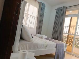 ein kleines Schlafzimmer mit einem Bett und einem Fenster in der Unterkunft Leisure apartment in Mombasa