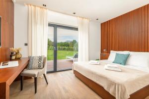a bedroom with a bed and a desk and a window at Villa Istria Green in Kršan +54 photos