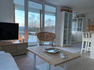 uma sala de estar com uma televisão e uma mesa de madeira em House with green garden, Göteborg, 6 beds em Lindome
