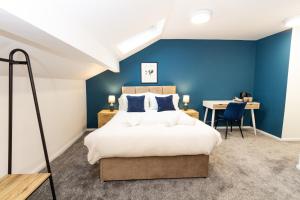 a bedroom with a large bed and a desk at Suite 7 - Family Room in the Heart of Oldham in Oldham