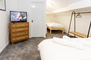 1 dormitorio con cama y vestidor con TV en Suite 7 - Family Room in the Heart of Oldham en Oldham