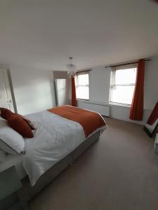 a bedroom with a bed and two windows at No. 6 The High Street in Royal Wootton Bassett