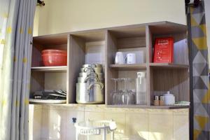 a kitchen with wooden shelves with utensils at Lux Suites Sunset Holiday Homes shanzu in Mombasa