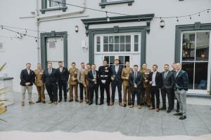 um grupo de homens de fato em pé em frente a um edifício em THE LORD NELSON HOTEL em Pembrokeshire