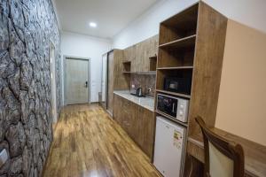 a kitchen with wooden cabinets and a counter top at ATLANTIS HOTEL in Sergeli