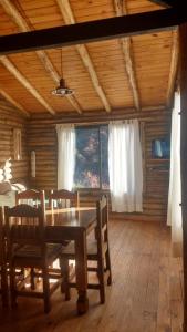 uma sala de jantar com uma mesa e cadeiras num camarote em Balcones del Portezuelo em Potrerillos