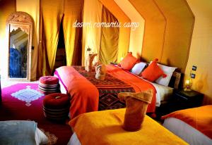 dwa koty siedzące na łóżku w pokoju w obiekcie Luxury Desert Romantic Camp w mieście Merzouga