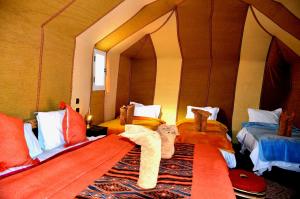 a bedroom with two beds in a room with an archway at Luxury Desert Romantic Camp in Merzouga