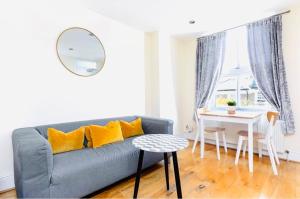 a living room with a blue couch and a table at Charming apartment, sleeps 4- 15 mins to Central in London