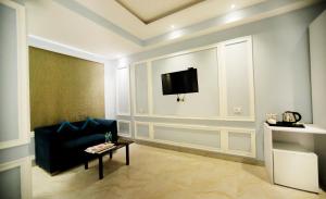 新德里的住宿－Hotel Stanley- Near Delhi Airport，客厅配有沙发和墙上的电视
