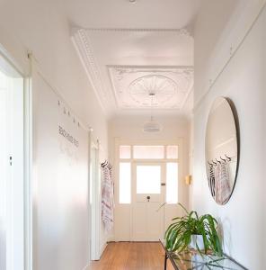 a hallway with a door and a mirror and a plant at Sea Glass Cottages Burnie Tasmania in Burnie