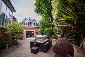 a patio with a table and chairs in front of a house at Eastfield Retreat with Hot Tub in Stannington