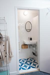 ein Bad mit einem Waschbecken und einem Spiegel in der Unterkunft L'atelier de Luc, Paris 20eme in Paris
