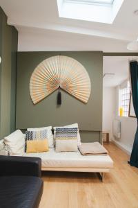 パリにあるL'atelier de Luc, Paris 20emeのソファ付きの客室で、壁に傘が付いています。
