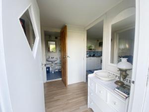 a bathroom with two sinks and two mirrors at Cozy cottage in Vejbystrand near the beach in Vejbystrand