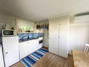 a kitchen with white cabinets and blue tiles at Cozy cottage in Vejbystrand near the beach in Vejbystrand