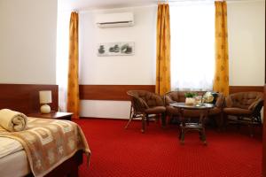 pokój hotelowy z łóżkiem, stołem i krzesłami w obiekcie Sala Bankietowa i Pokoje Gościnne w mieście Sokółka +37 zdjęć