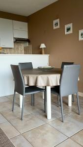 a dining room table with two chairs and a counter at Superbe studio avec une magnifique vue sur la mer. in De Panne