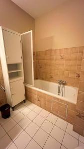 une salle de bain avec baignoire et sol carrelé dans l'établissement Superbe studio avec une magnifique vue sur la mer., à La Panne 8 autres photos