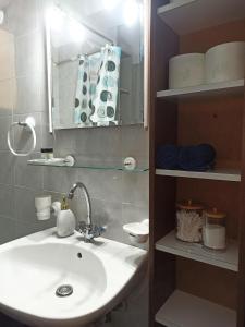 La salle de bains est pourvue d'un lavabo et d'un miroir. dans l'établissement Deluxe Lodge, à Vólos