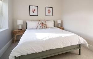 a bedroom with a white bed with two night stands at 22 The Old Market in Yarm