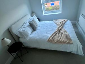 a bedroom with a bed with white sheets and a window at 22 The Old Market in Yarm