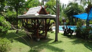 - un kiosque dans une cour à côté d'une piscine dans l'établissement Riverside, à Ban Cho Lae