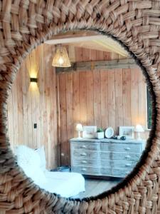 ein Schlafzimmer mit einer Kommode und einem Spiegel in der Unterkunft Pierres et Jardins in Senlis