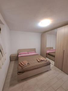 ein Schlafzimmer mit einem großen Bett und einem Spiegel in der Unterkunft La casa di Dino Pari, Petriolo in Pari
