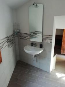 ein Bad mit einem Waschbecken und einem Spiegel in der Unterkunft La casa di Dino Pari, Petriolo in Pari