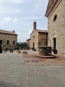 ein altes Steingebäude mit einem Brunnen im Innenhof in der Unterkunft La casa di Dino Pari, Petriolo in Pari
